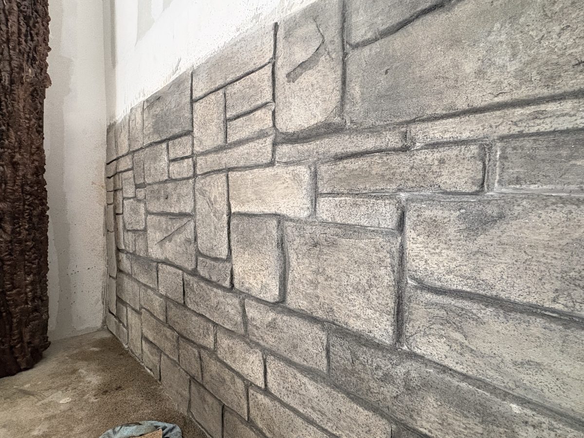 Close-up detail of a hand-sculpted brick and stone textured wall