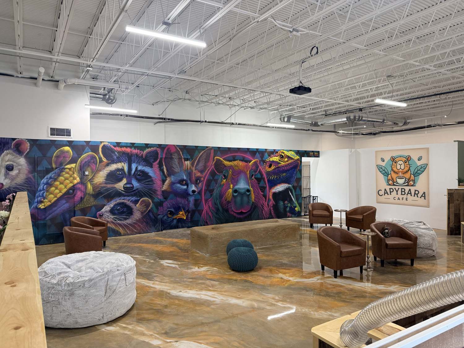 Main cafe lounge with the animal mural, leather chairs, and Capybara Cafe sign